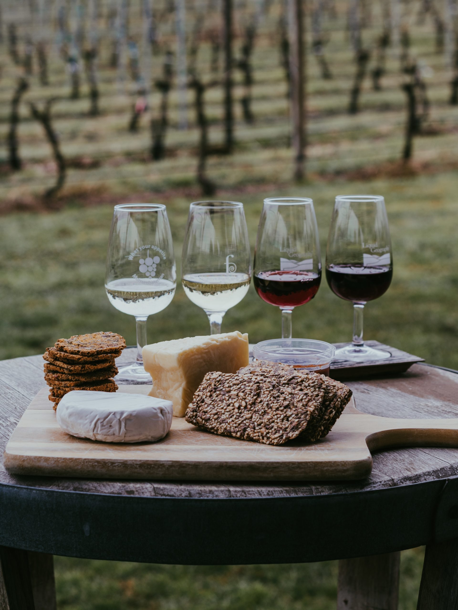 A selection of wines and cheeses on a rustic table.